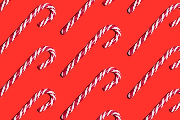 Foto patrón de piruletas de caramelo sobre un fondo rojo feliz año nuevo y navidad