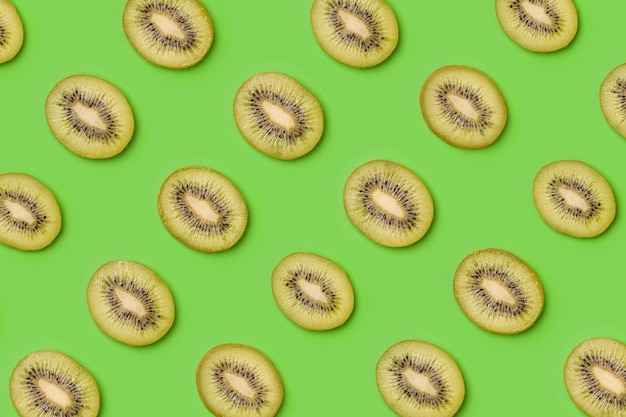 Patrón de rodajas de kiwi sobre fondo verde Fondo de alimentos Patrón de frutas Diseño de arte pop concepto creativo de verano