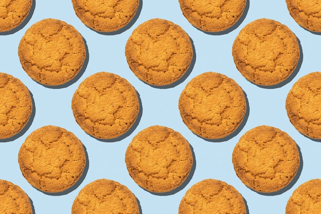 Patrón de tendencia sin fisuras de galletas de avena saludable aislado sobre fondo azul.