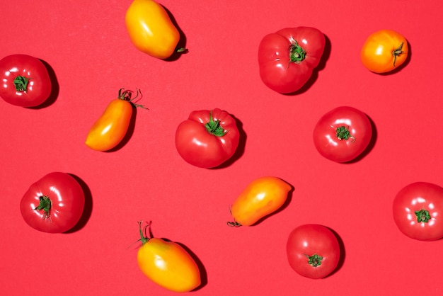 Patrón de tomates amarillos y rojos sobre fondo rojo