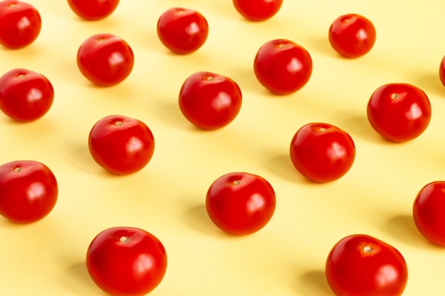 Patrón de tomates rojos sobre un fondo amarillo claro.