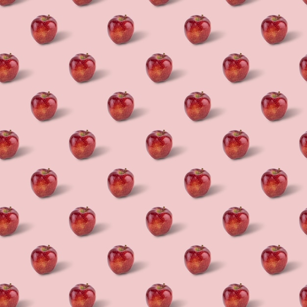 Patrón transparente de manzana deliciosa roja fresca sobre fondo rosa