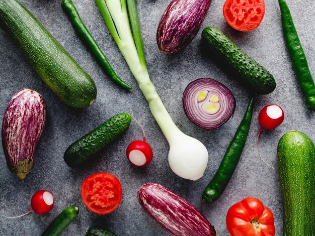 Patrón de verano colorido con diferentes verduras frescas sobre un fondo gris Vista superior plana