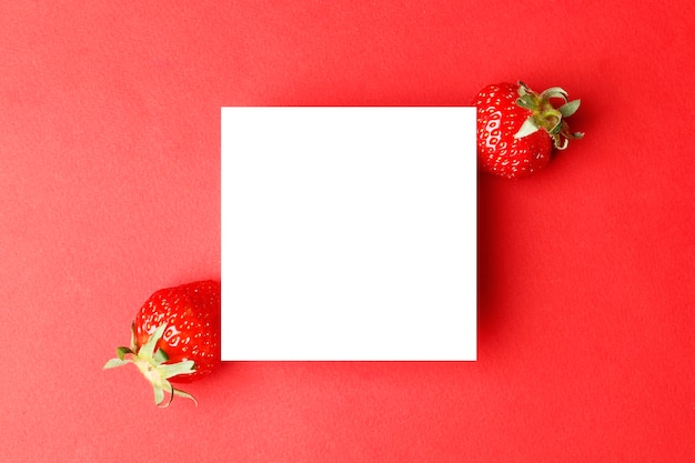 Patrón de verano creativo hecho de fresas sobre fondo rojo brillante. con marco. Concepto mínimo de fruta. Endecha plana. espacio para texto. Abstracto.