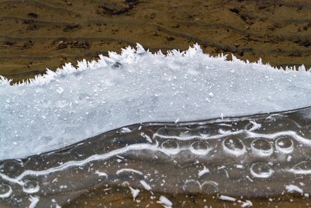 Patrones de encaje del borde del agua congelada en el estanque