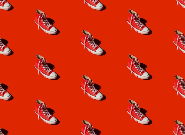 Foto patrones sin fisuras con zapatillas sobre fondo rojo