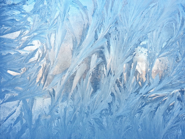 Patrones helados en el primer plano de cristal de la ventana. texturas y fondos naturales. patrones de hielo en congelado