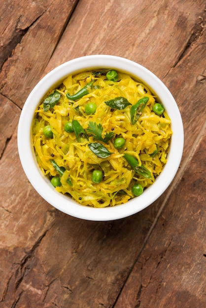 Patta Gobi Sabji OU repolho sabzi com ervilhas e folhas de curry, servido em uma tigela sobre um fundo sombrio, foco seletivo