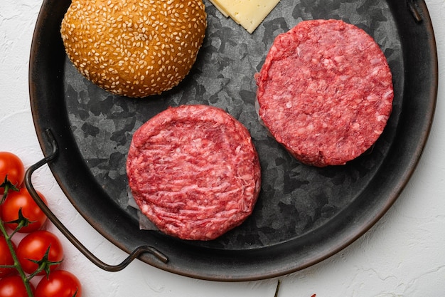 Foto patty de hamburguesa en la vista superior de fondo de mesa de piedra blanca endecha plana