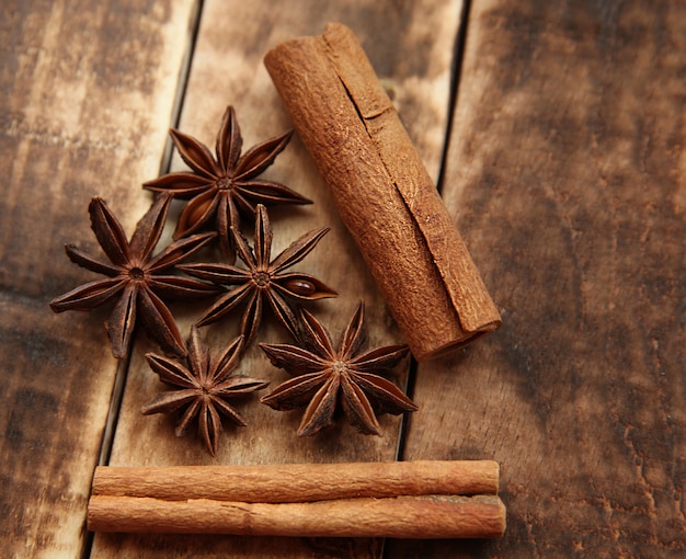 Paus de canela e anis estrelado em um fundo escuro de madeira