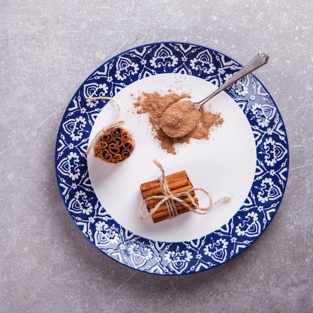 Paus de canela e canela em pó no prato