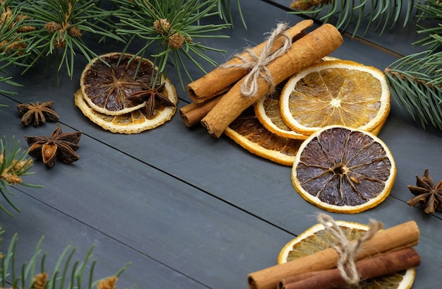 Paus de canela e laranjas secas com galhos de árvores de Natal.