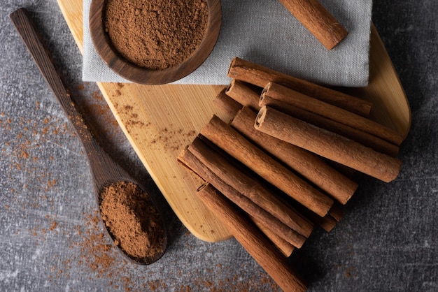 Paus de canela em um fundo de madeira. Especiaria de canela em uma colher e tigela. Canela do Ceilão.