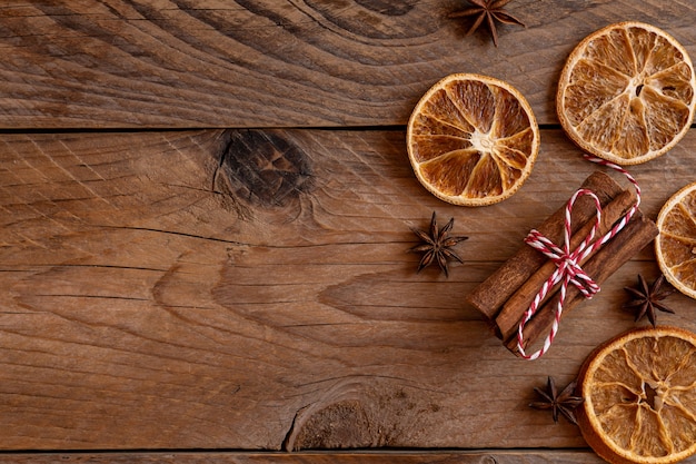 Paus de canela, fatias de laranja seca, anis estrelado em fundo de madeira com espaço de cópia. Vista do topo. Conceito de celebração de Natal e ano novo.