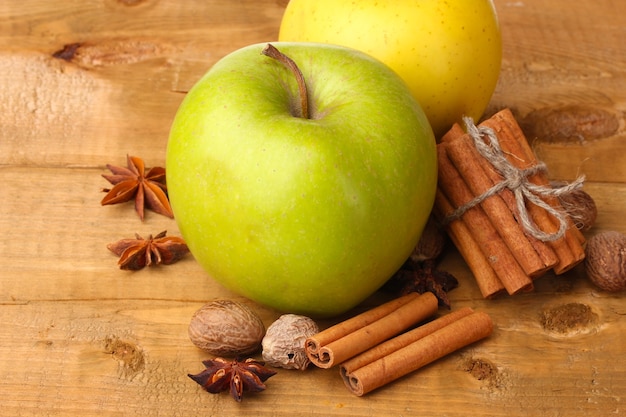 Paus de canela, maçãs, noz-moscada e anis na mesa de madeira