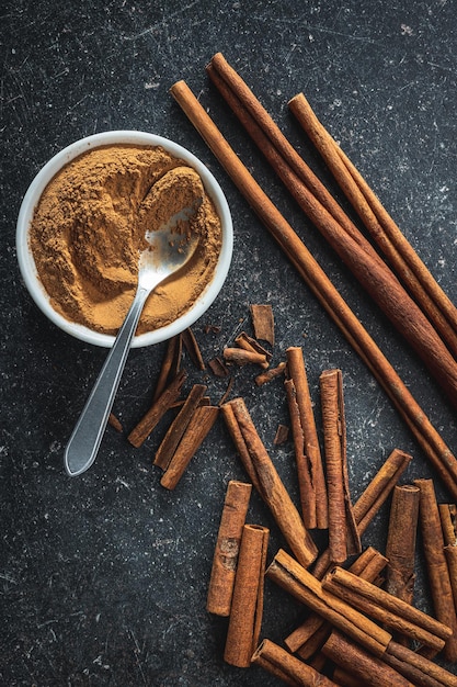 Foto paus de canela secos e canela em pó em uma mesa de cozinha vista superior especiaria de canela