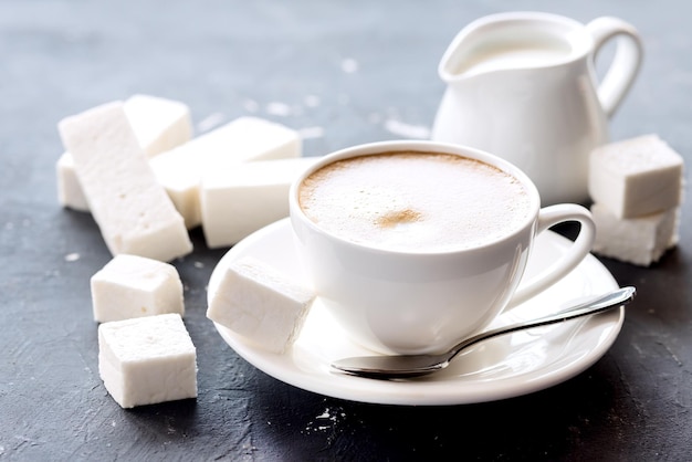 Paus de marshmallow deitado no fundo Copa com creme de café preto fresco