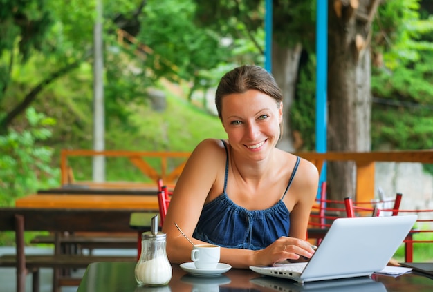 Pausa para el café joven que trabaja con el portátil