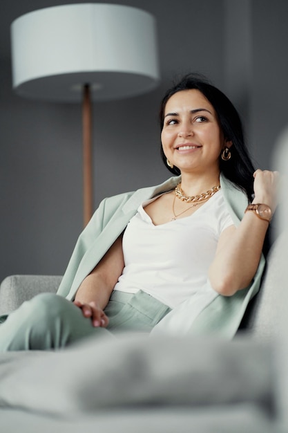 Pausa durante o trabalho sorrindo sentado no sofá em um escritório moderno gerente experiente confiante