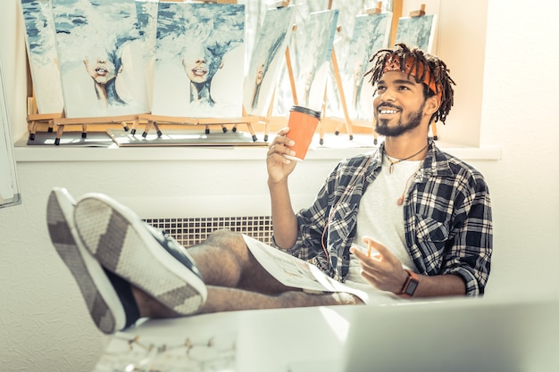 Pausa para o café. Jovem e promissora artista talentosa se sentindo aliviada durante a pausa para o café