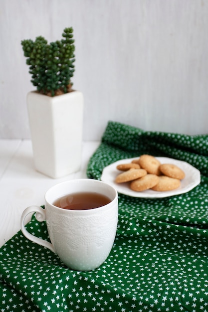pausa saborosa. xícara de chá com um prato de biscoitos.