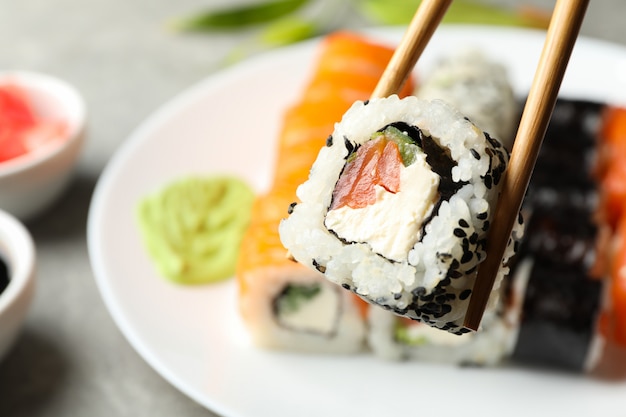 Pauzinhos com rolo de sushi delicioso. Comida japonesa