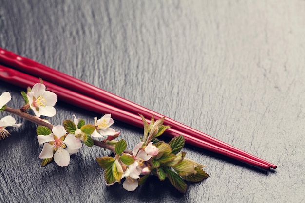 Pauzinhos de sushi japonês e flor de sakura