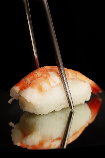 Pauzinhos e rolos de sushi servidos na placa de pedra com espaço de cópia