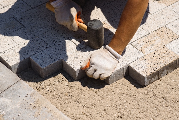 Paver está colocando pedras de pavimentação Colocando pedras de pavimentação de concreto