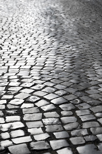 Pavimento de adoquines en la superficie de la calle de adoquines de la ciudad al atardecer