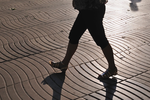 Pavimento de azulejos com padrão de ondas na famosa rua la rambla, em barcelona, com a silhueta de uma mulher caminhando