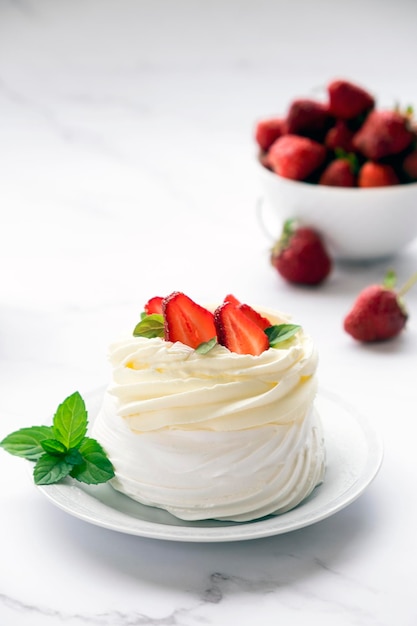 Pavlova-Baiser-Kuchen mit frischen Erdbeeren und Schlagsahne-Mascarpone mit Minzblättern. Rezept für ein traditionelles Dessert von Anna Pavlova. Hausgemachtes Gebäck