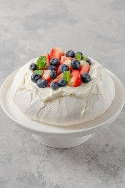 Pavlova-Baiser-Kuchen mit Schlagsahne und frischen Beeren an der Spitze Sommerdessert Kopierbereich