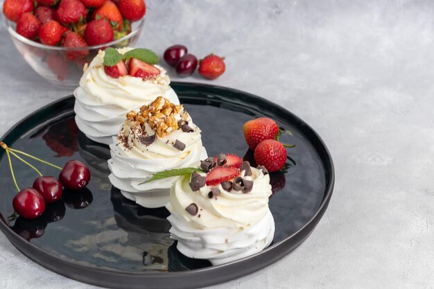 Pavlova-Baiser-Kuchen mit Schlagsahne und frischen Erdbeerminzblättern Selektiver Fokus