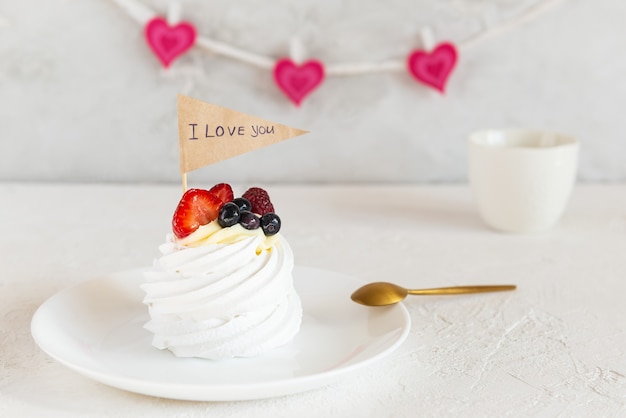 Pavlova Kuchen mit der Inschrift Ich liebe dich auf den Herzen