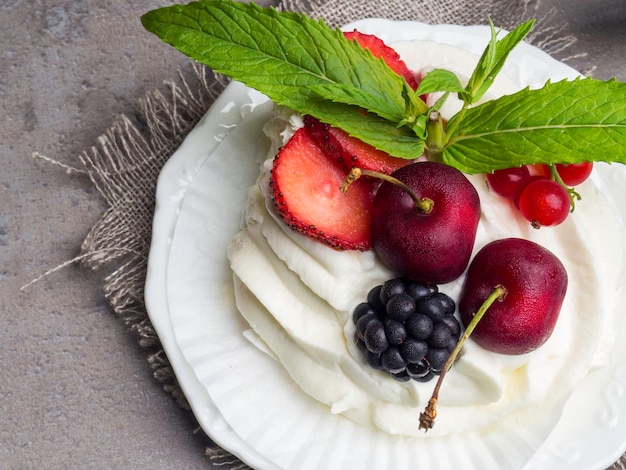 Pavlova Un pastel hecho con capas de crema batida de merengue y bayas frescas