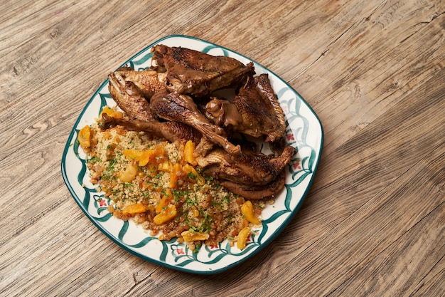 Pavo asado y cuscús sobre fondo de mesa de madera con espacio de copia.