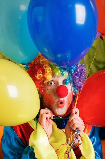 Payaso con un montón de globos de colores.