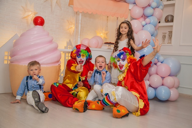 Payaso niño y niña payaso en fiesta infantil divirtiéndose con niños