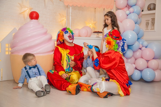 Payaso niño y niña payaso en fiesta infantil inflar globos