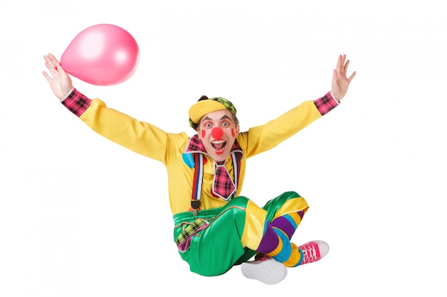 Payaso siots con un globo en una mano aislado sobre un fondo blanco.