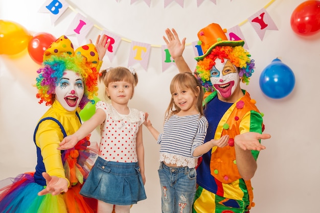 Payasos divertidos en la fiesta muestran sus buenas emociones con una chica