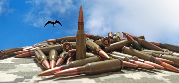 Foto paz e guerra armas para a guerra conceito de guerra pila de cartuchos com balas pila de balas contra o pôr do sol nublado conceito militar pila de balas