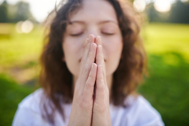 Paz por dentro. Um jovem ruivo meditando no parque e parecendo tranquilo