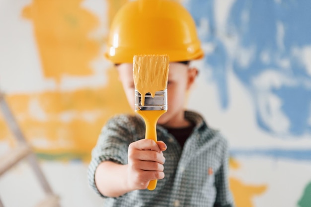 Foto paz en ucrania colores azul y amarillo niño pintando paredes en la habitación doméstica