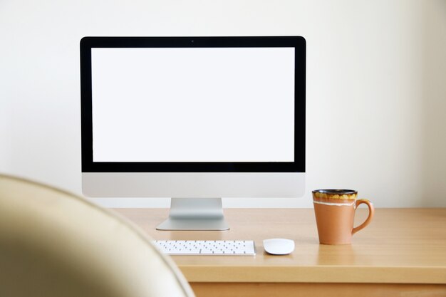 PC con pantalla de computadora y taza de café con leche para negocios en la mesa