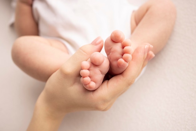 Pé de criança nas mãos da mãe pai pais Pés de um recém-nascido minúsculo perto Pernas de bebê mãe e seu filho Conceito de família feliz Linda imagem conceitual da maternidade foto de stock