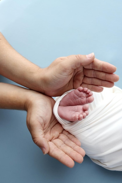 Pé minúsculo de um bebê recém-nascido Pernas macias de um recém-nascido em um cobertor branco Feche os dedos, calcanhares e pés de um bebê recém-nascido Macro fotografia de estúdio pés de bebê em um fundo branco