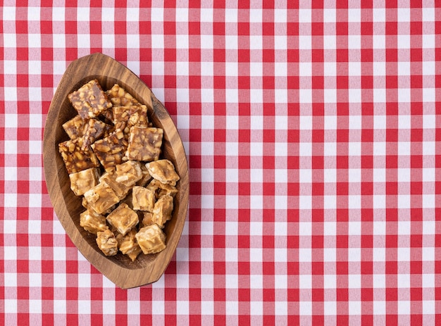 Pe de moleque típico dulce de maní brasileño sobre tela escocesa comida del festival de junio