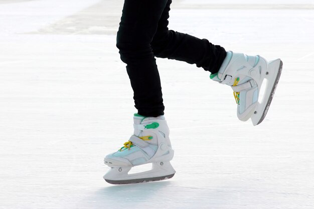 Pé patinando na pista de gelo. esporte e entretenimento. descanso e férias de inverno.